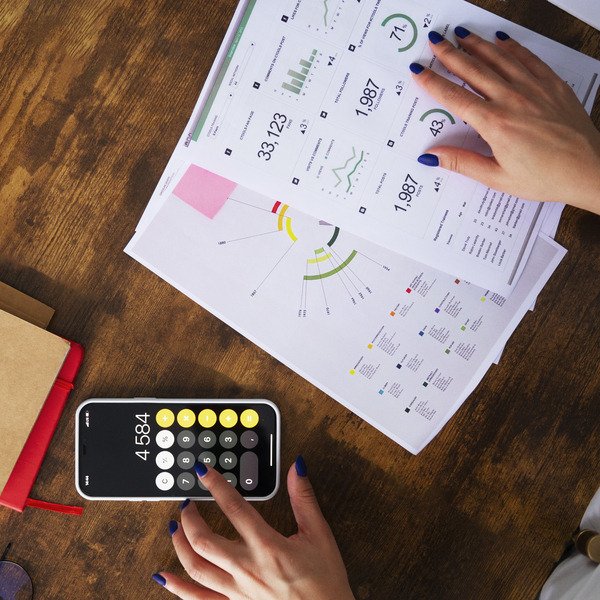 Image of power consumption calculations with charts and a calculator, illustrating energy use for appliances in an RV