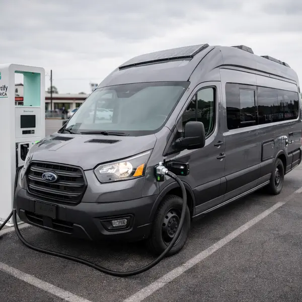 Spacious Winnebago eRV2 electric RV interior showing modern kitchen with induction cooktop and comfortable living area with premium finishes and natural lighting