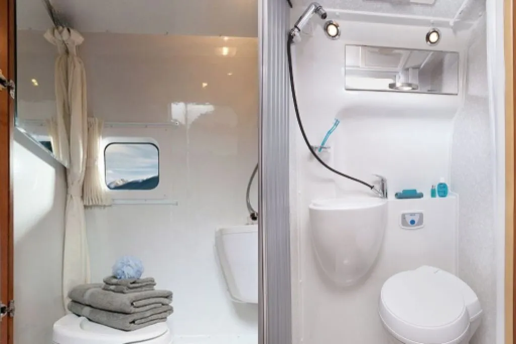 Compact RV bathroom with shower, toilet, and storage in a small camper interior